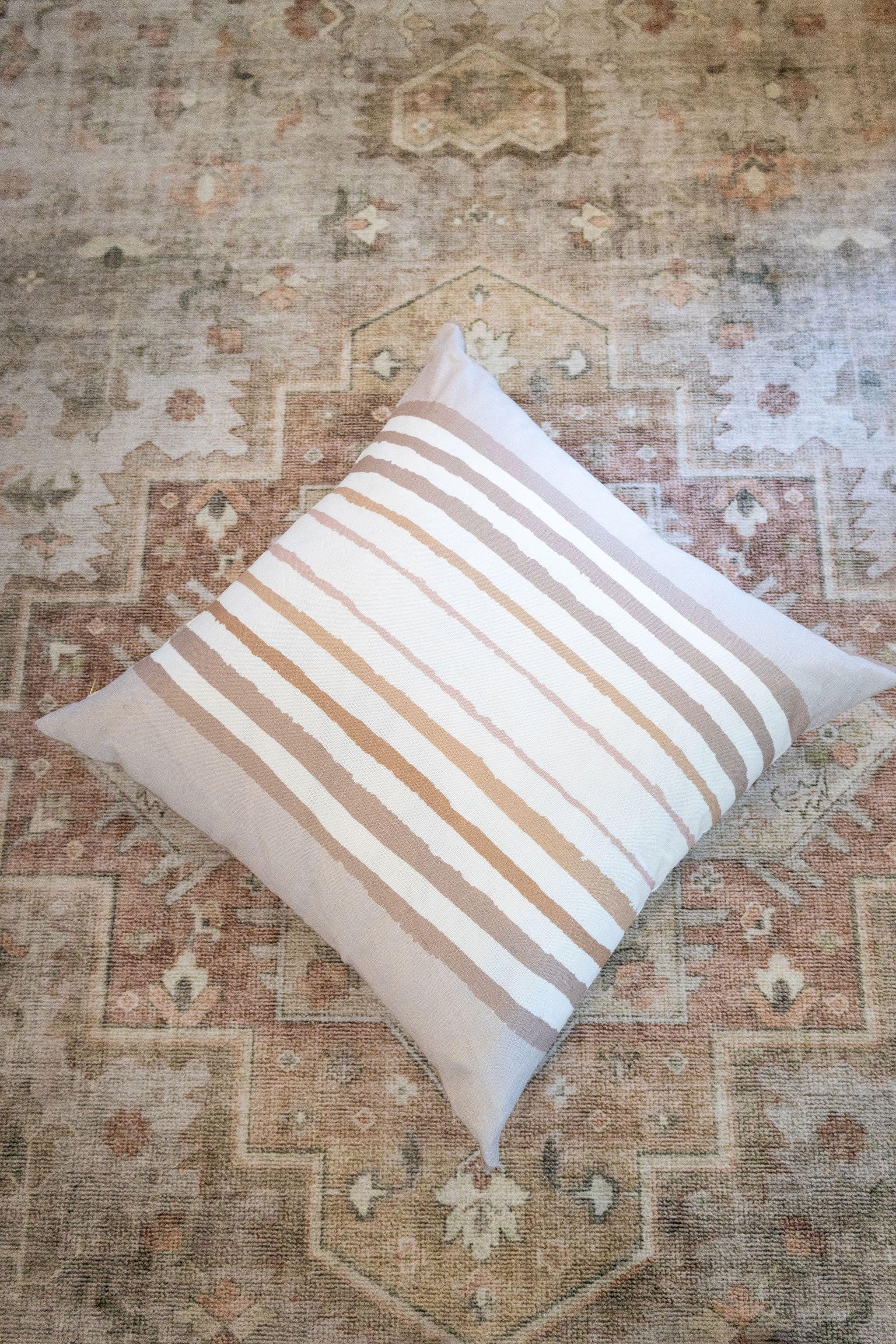 Brother Stripe in Neutrals Luxury Pillow by Truett Designs featuring an artistic stripe pattern in warm neutral tones. Handcrafted in England from sustainably printed luxury fabric, this designer decorative pillow adds structure, texture, and timeless elegance to sofas, beds, and accent chairs. A versatile favorite for interior designers, it pairs beautifully with florals, botanicals, grasscloth, natural linens, and tailored upholstery in luxury residential interiors.