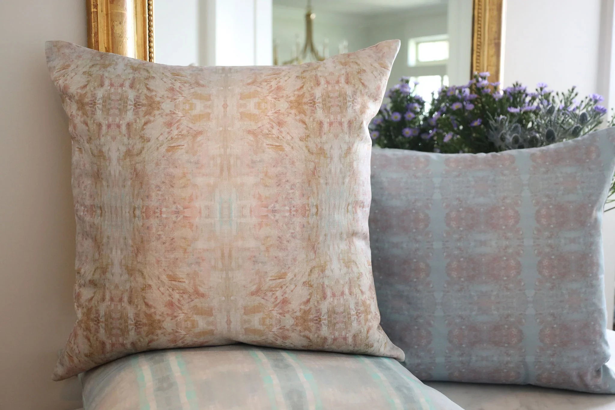 The Gardens Bronze Iris luxury decorative pillow featuring an abstract floral pattern with layered artistic movement and rich bronze, plum, and earthy tones, handcrafted in England for luxury living rooms, designer-curated interiors, thoughtfully layered spaces, and modern traditional homes.