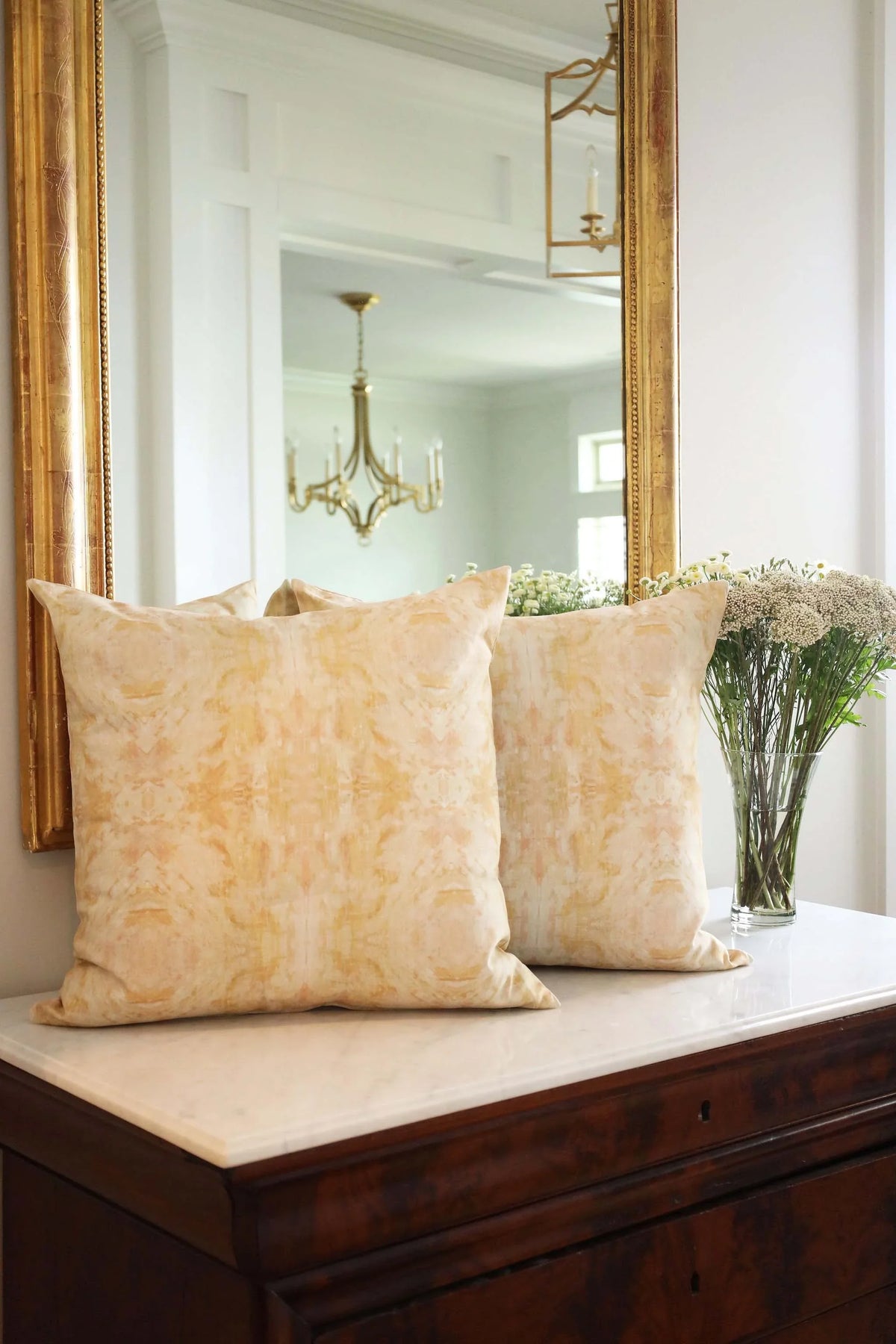 Luxury decorative pillow featuring an abstract topiary-inspired pattern in warm autumn gold and neutral tones, styled for a layered modern traditional interior.
