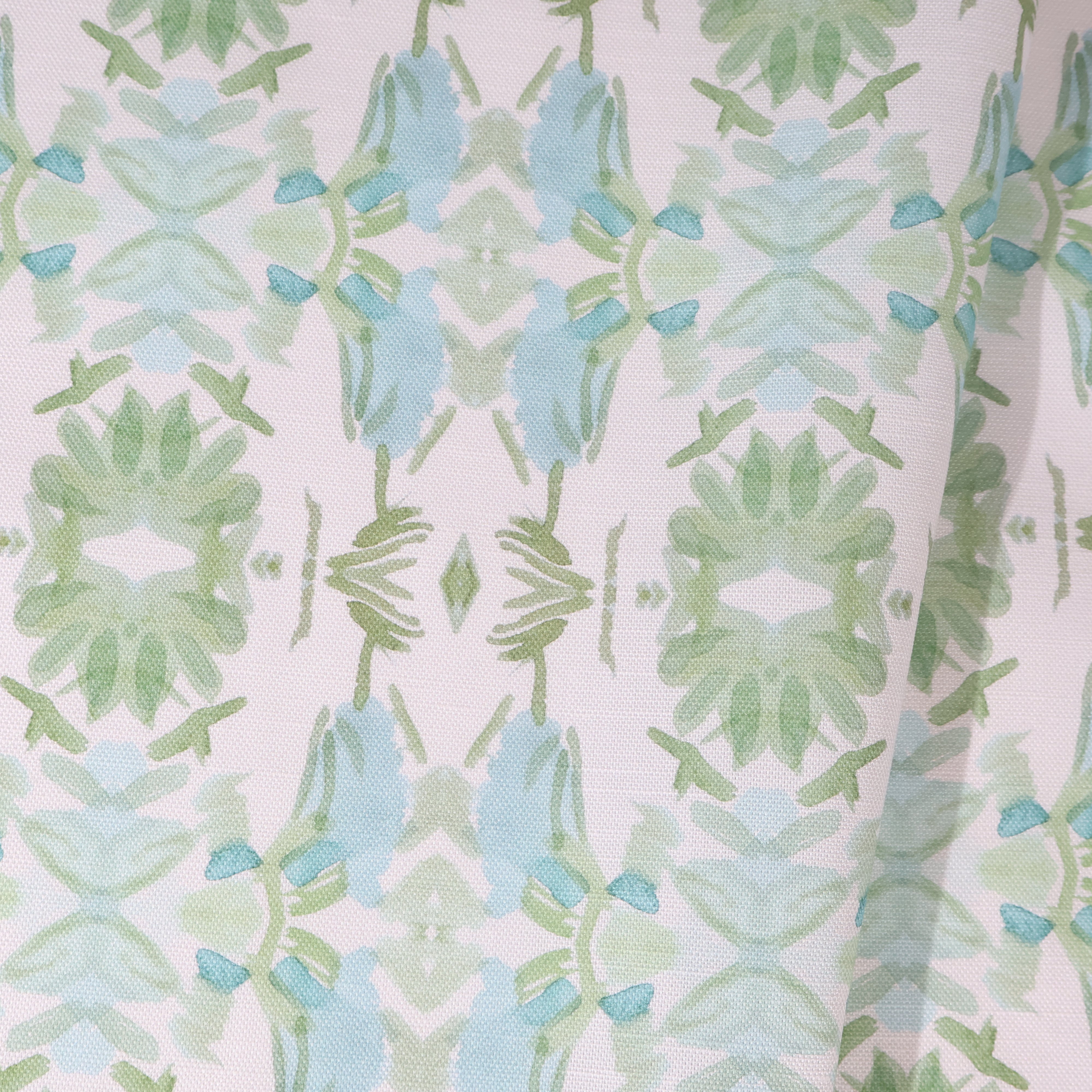 Luxury botanical fabric featuring layered wildflower patterns in sage green, soft blue, and natural tones for modern traditional and collected interiors.
