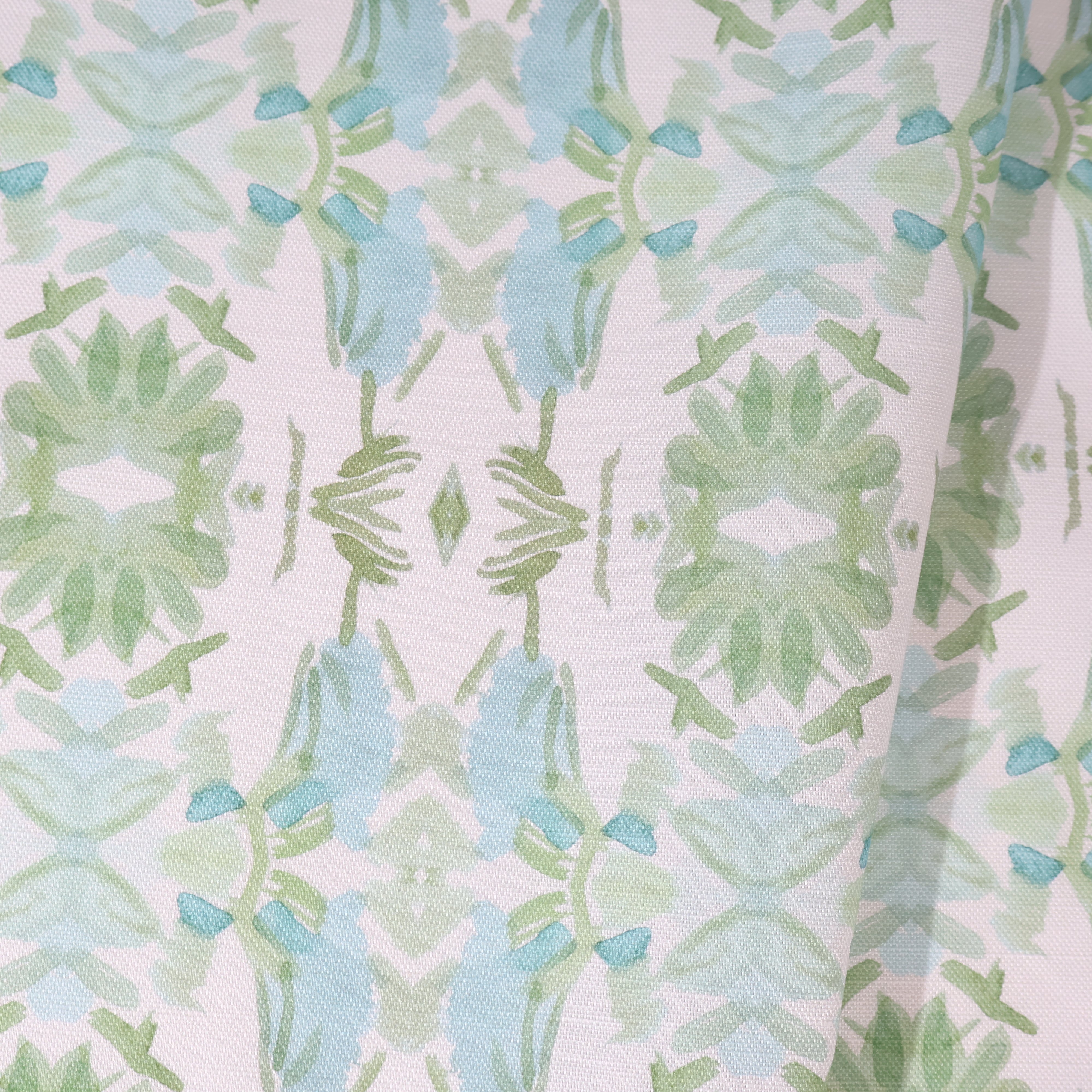 Luxury botanical fabric featuring layered wildflower patterns in sage green, soft blue, and natural tones for modern traditional and collected interiors.
