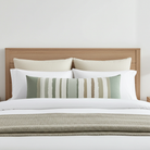 Luxury green stripe bolster pillow with bold linear pattern, handcrafted in England for contemporary and modern traditional interiors.