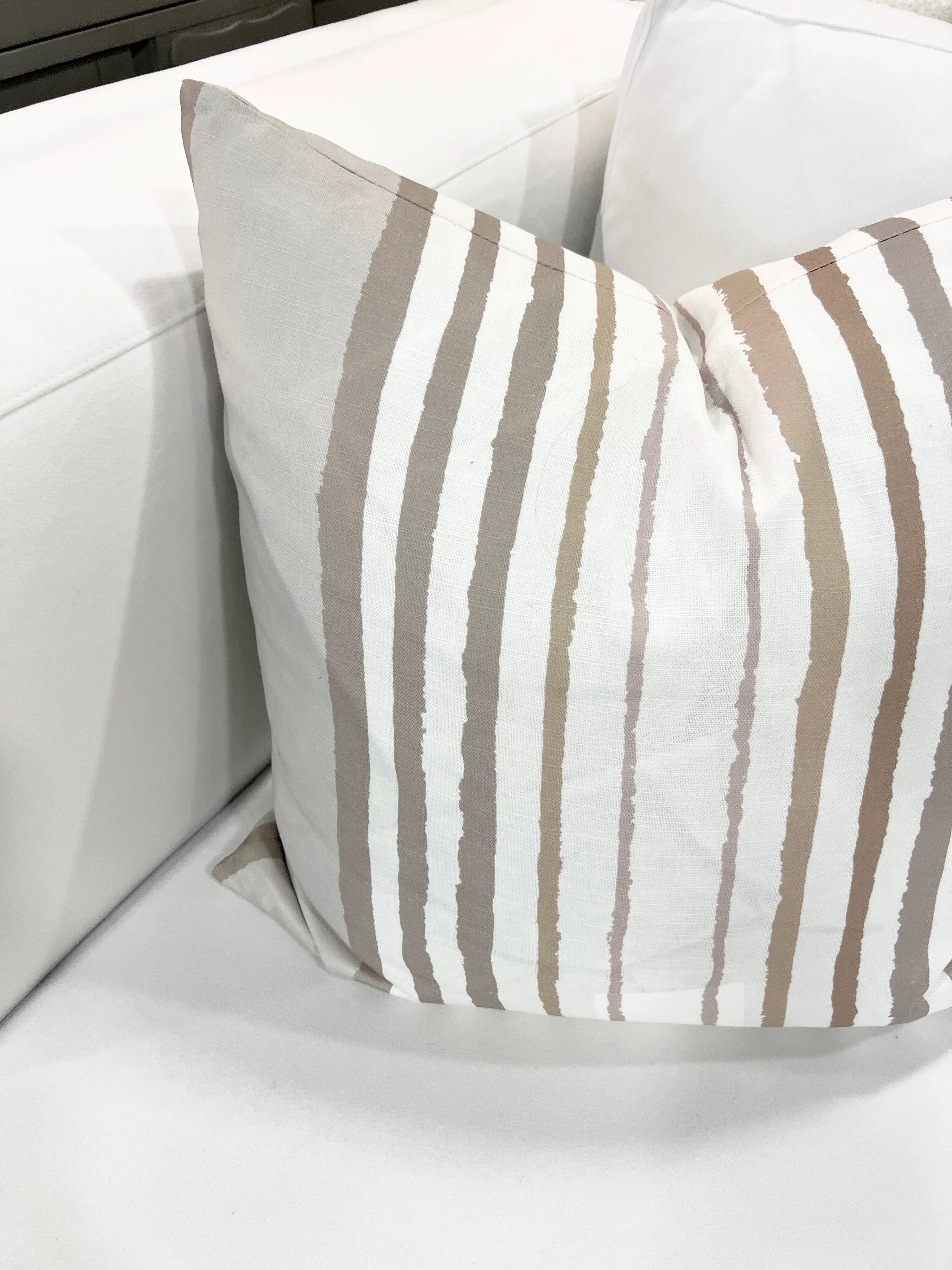 Brother Stripe in Neutrals Luxury Pillow by Truett Designs featuring an artistic stripe pattern in warm neutral tones. Handcrafted in England from sustainably printed luxury fabric, this designer decorative pillow adds structure, texture, and timeless elegance to sofas, beds, and accent chairs. A versatile favorite for interior designers, it pairs beautifully with florals, botanicals, grasscloth, natural linens, and tailored upholstery in luxury residential interiors.