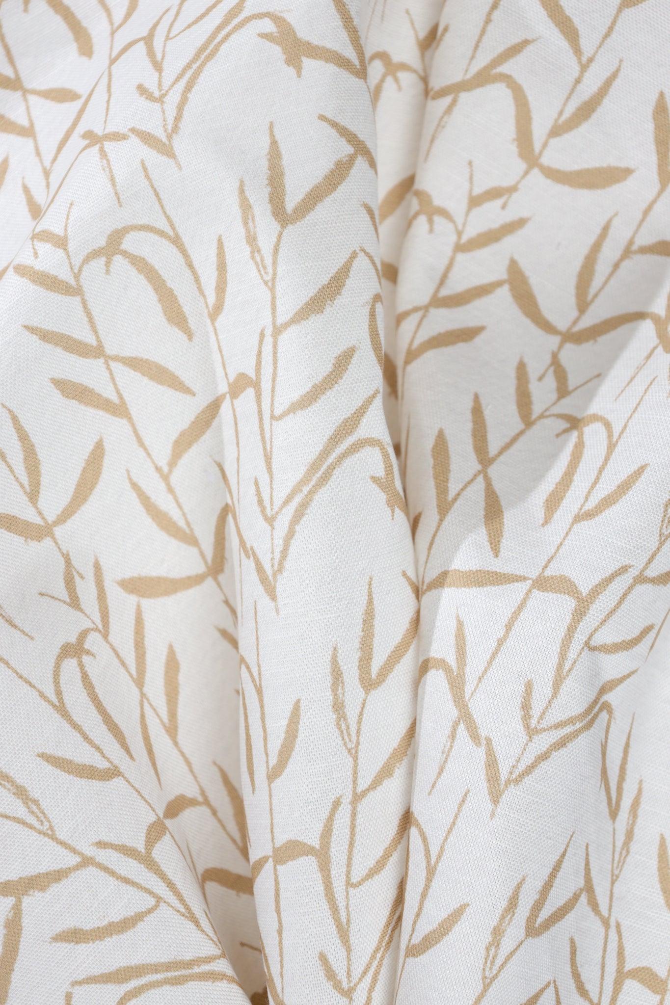 Luxury botanical fabric in warm brass tones with layered painterly organic design, ideal for upholstery, drapery, and sophisticated contemporary interiors.