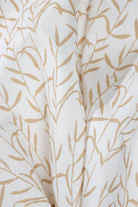 Luxury botanical fabric in warm brass tones with layered painterly organic design, ideal for upholstery, drapery, and sophisticated contemporary interiors.