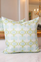 Luxury decorative pillow featuring an abstract small repeat pattern in chartreuse green and soft blue tones, styled for a layered modern traditional interior.