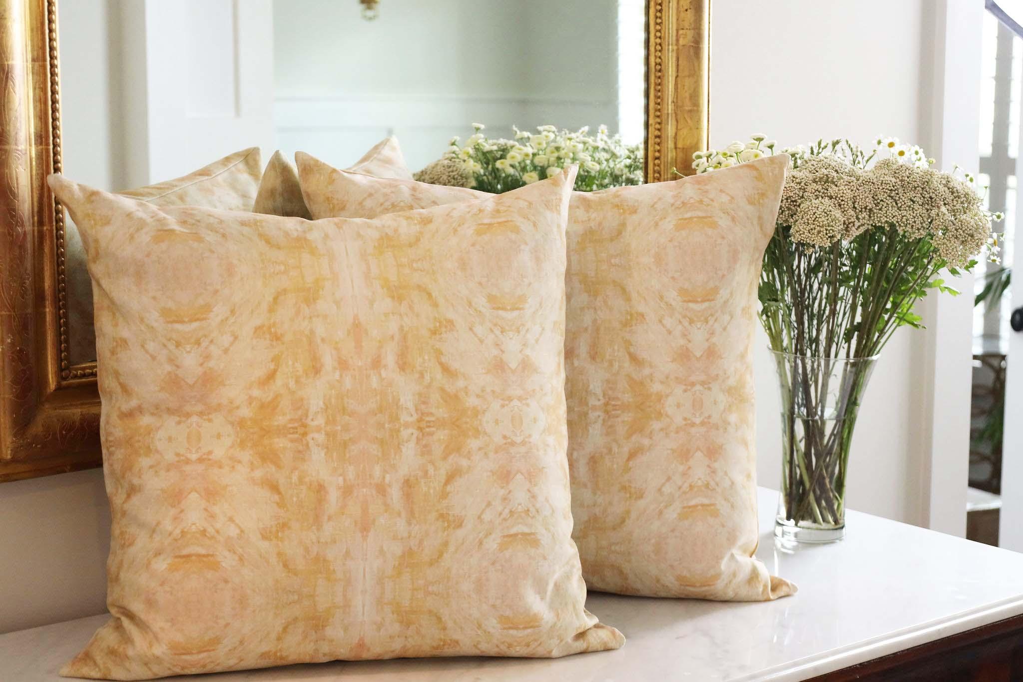 Luxury decorative pillow featuring an abstract topiary-inspired pattern in warm autumn gold and neutral tones, styled for a layered modern traditional interior.