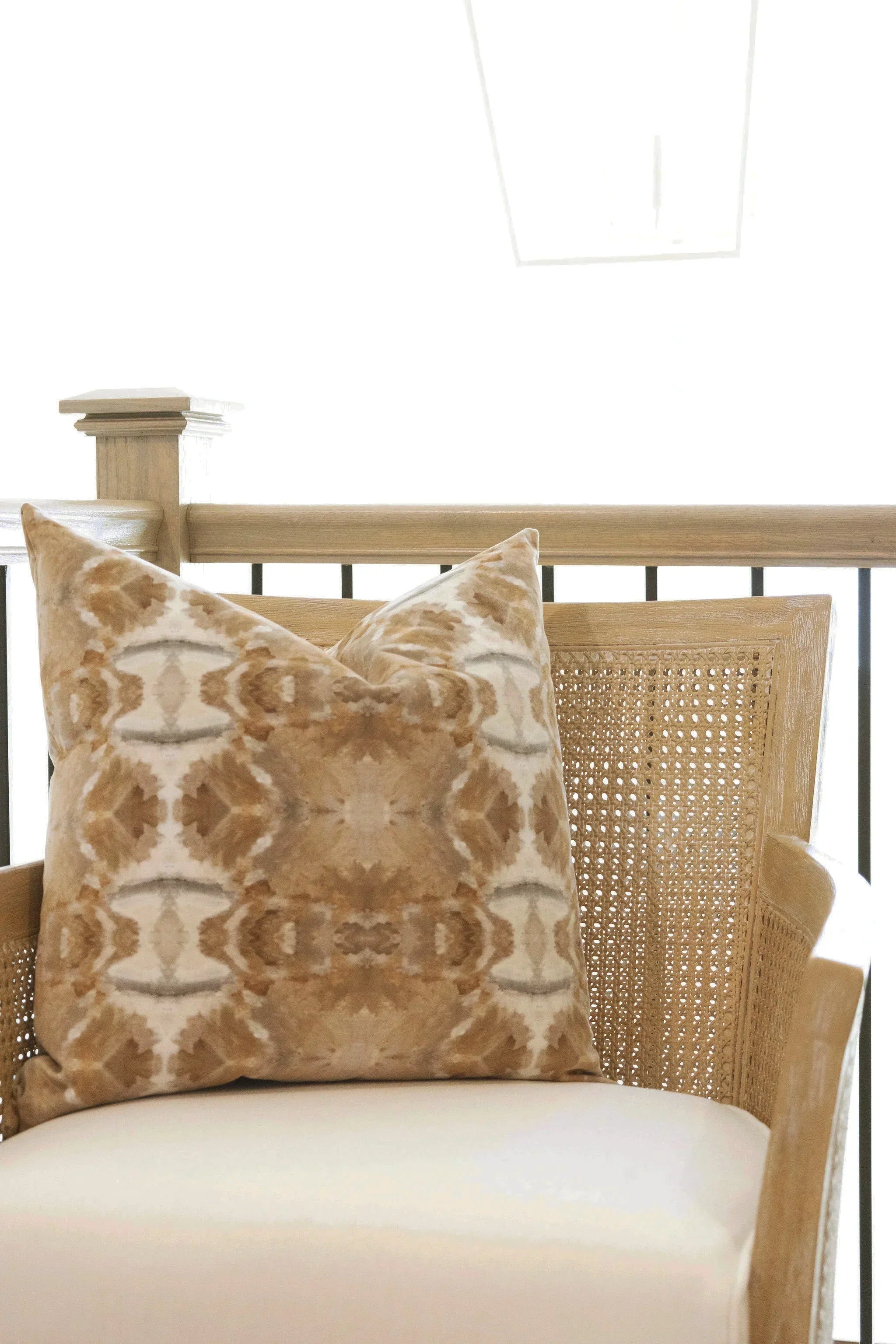 Luxury decorative pillow featuring an organic tree-inspired pattern in warm cognac and neutral tones, styled for a layered modern traditional interior.