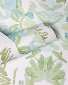 Luxury botanical wallpaper featuring an artistic wildflower-inspired pattern in sage green and soft blue, designed for modern traditional interiors, powder rooms, bedrooms, dining rooms, and collected homes.