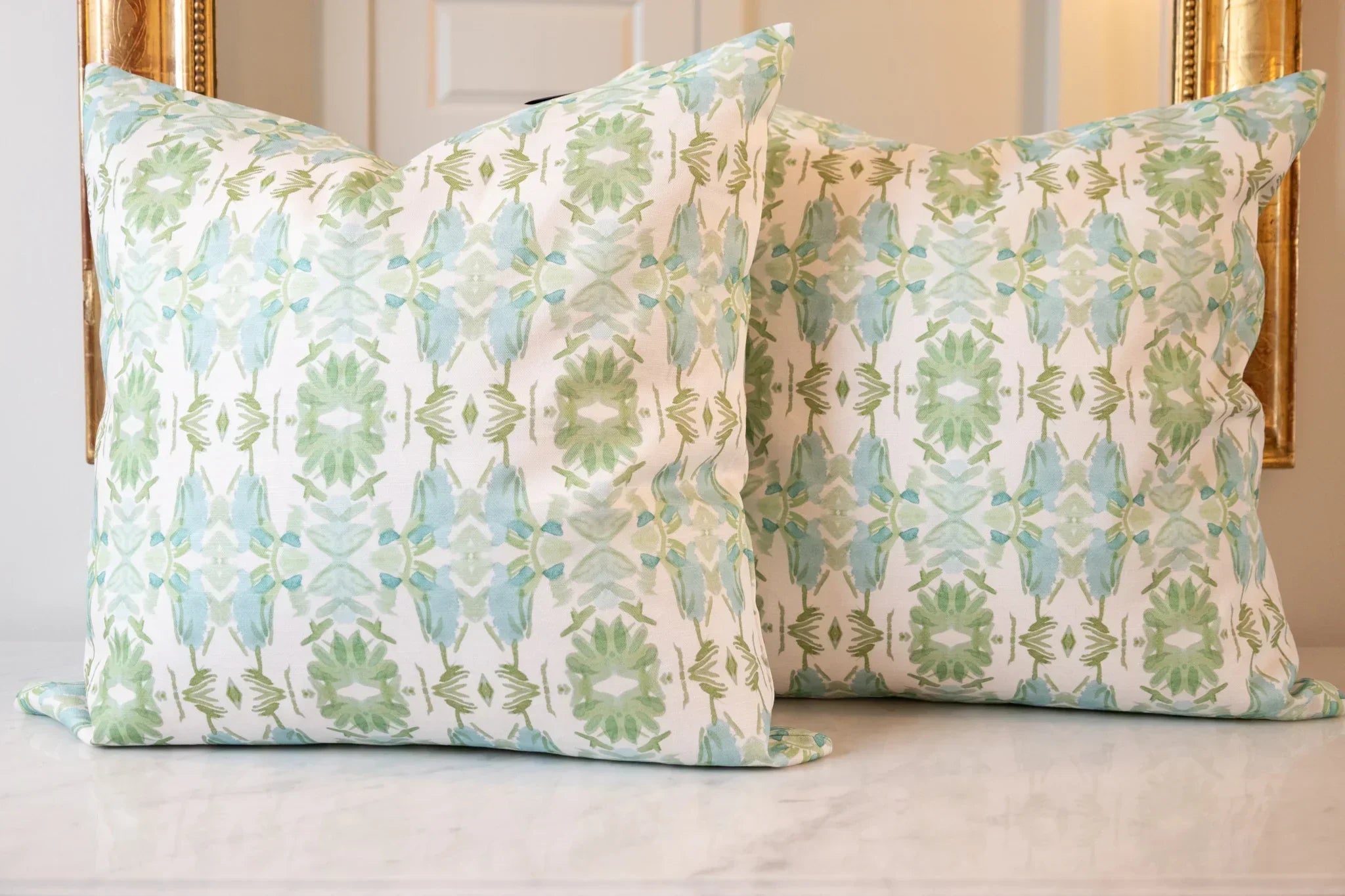 Luxury sage green and powder blue botanical pillow with large-scale floral pattern inspired by Alaska wildflowers, handcrafted in England and styled for contemporary and traditional interiors.
