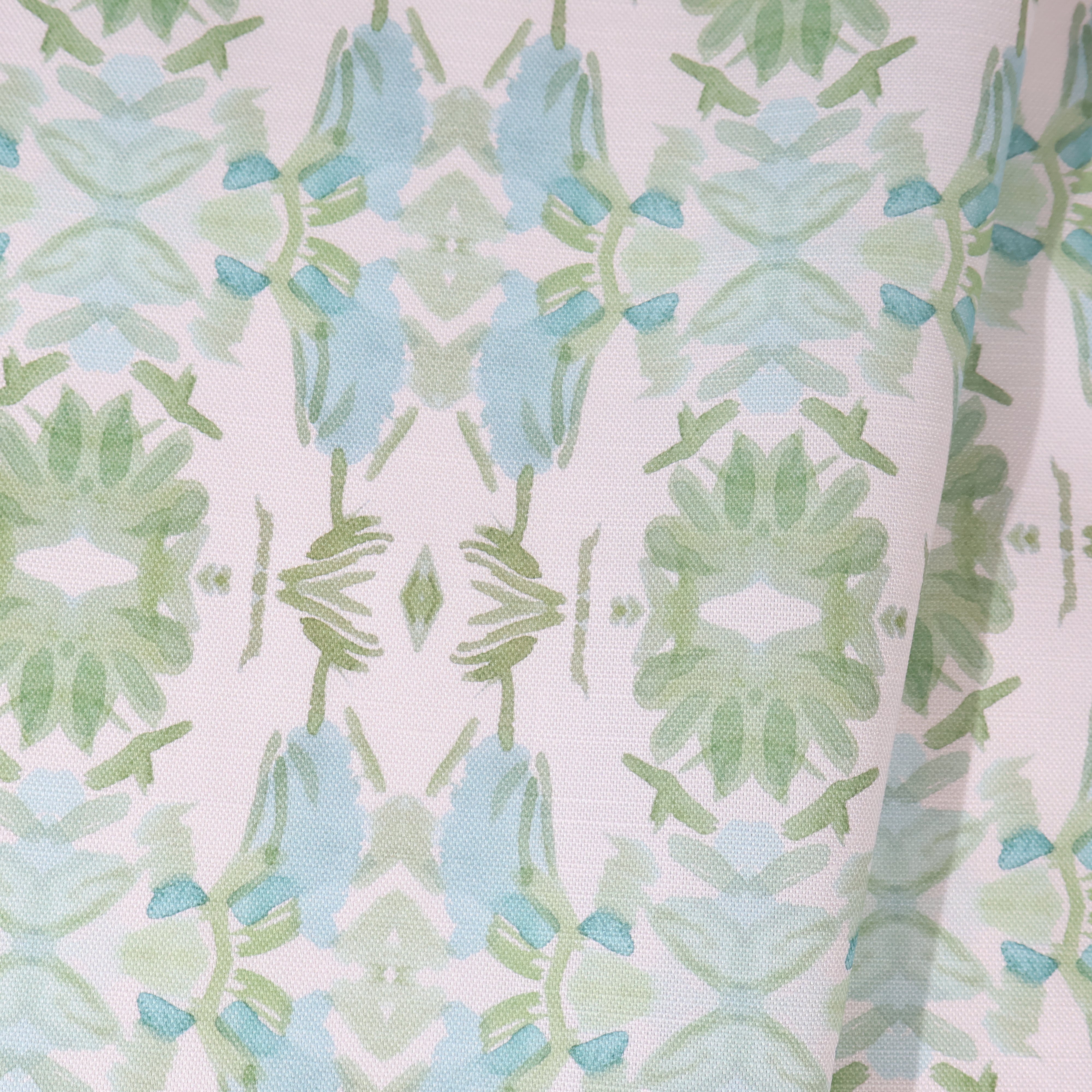 Luxury botanical fabric featuring layered wildflower patterns in sage green, soft blue, and natural tones for modern traditional and collected interiors.