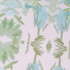 Luxury botanical fabric featuring layered wildflower patterns in sage green, soft blue, and natural tones for modern traditional and collected interiors.