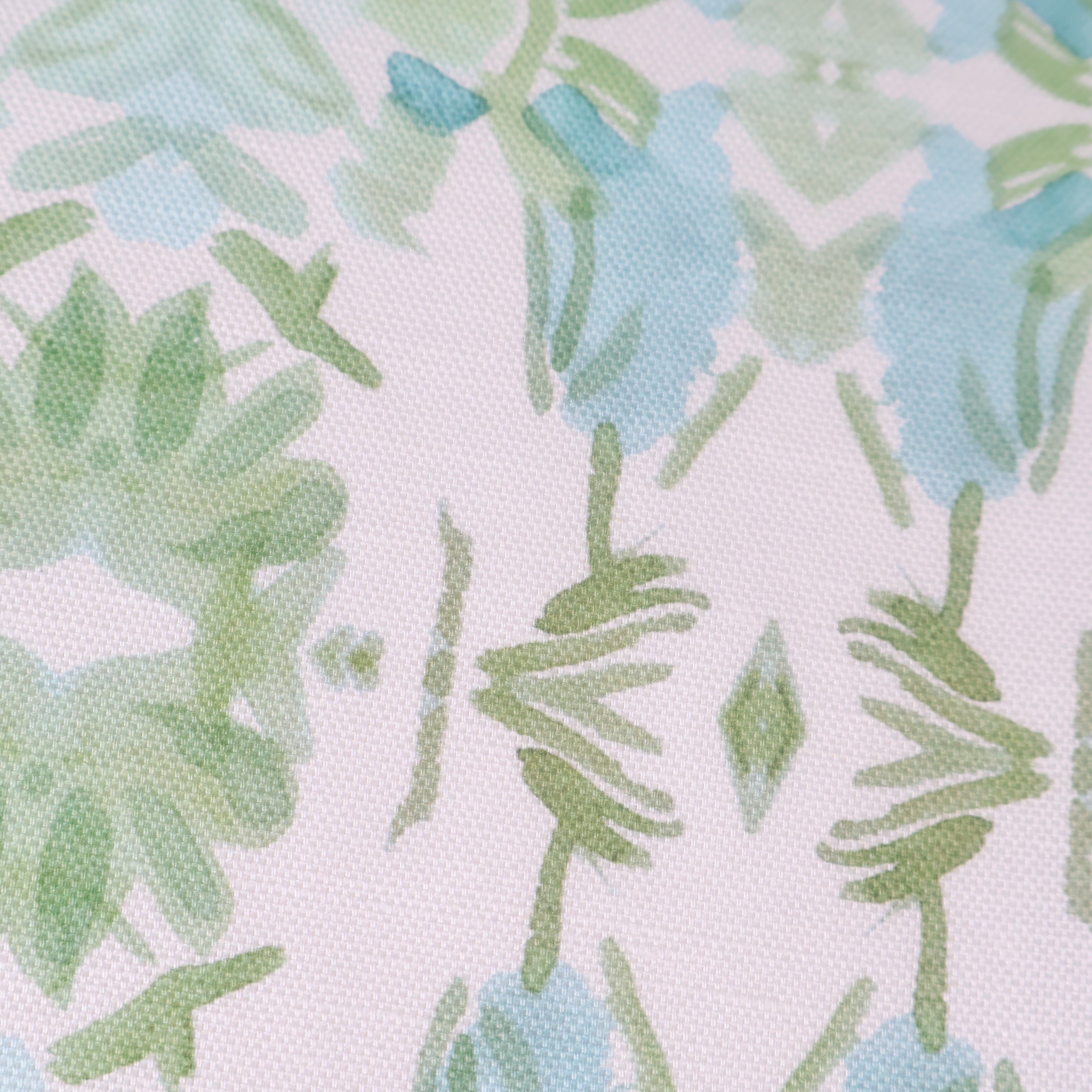 Luxury botanical fabric featuring layered wildflower patterns in sage green, soft blue, and natural tones for modern traditional and collected interiors.
