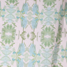 Luxury botanical fabric featuring layered wildflower patterns in sage green, soft blue, and natural tones for modern traditional and collected interiors.