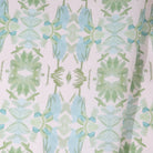 Luxury botanical fabric featuring layered wildflower patterns in sage green, soft blue, and natural tones for modern traditional and collected interiors.