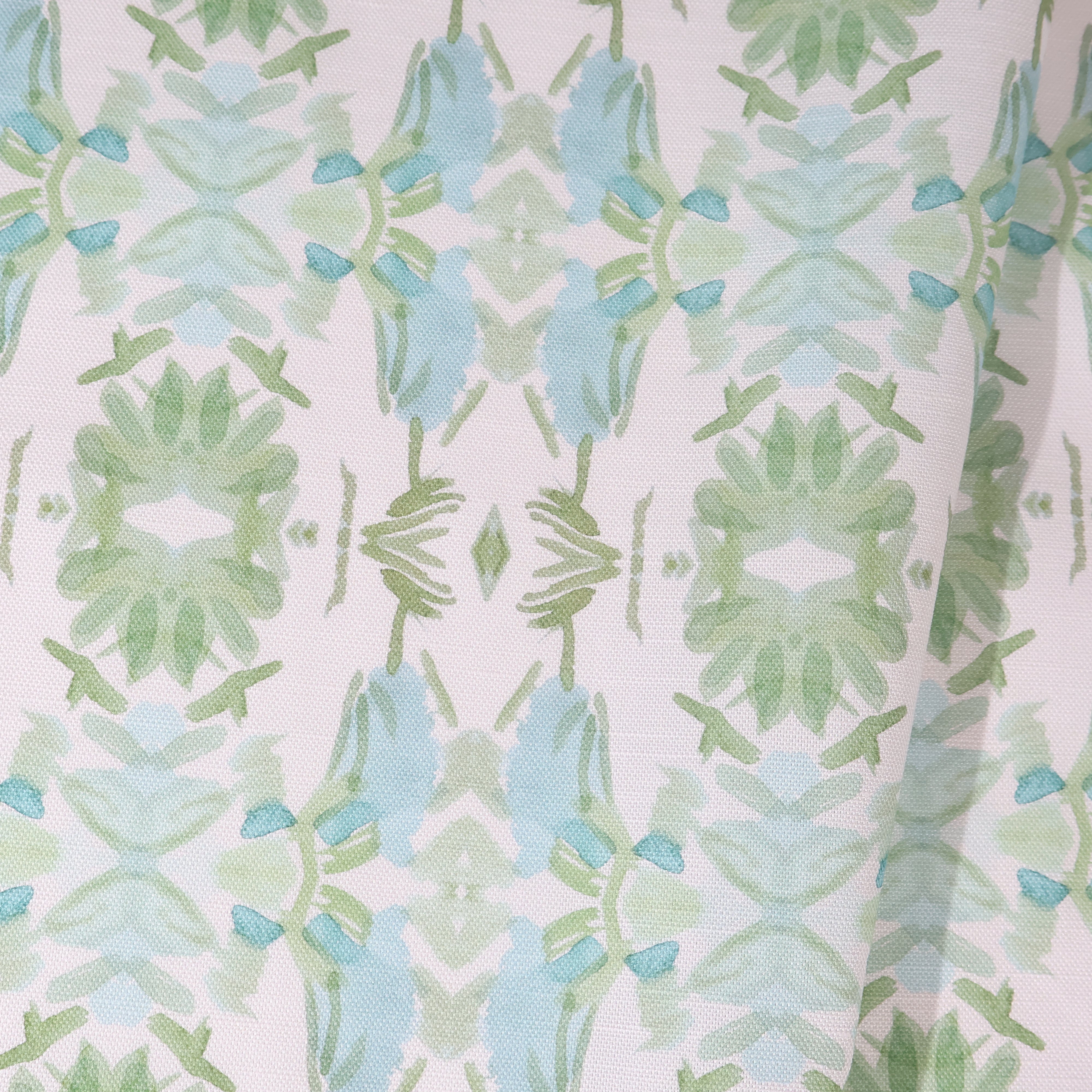 Luxury botanical fabric featuring layered wildflower patterns in sage green, soft blue, and natural tones for modern traditional and collected interiors.