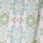Luxury botanical fabric featuring layered wildflower patterns in sage green, soft blue, and natural tones for modern traditional and collected interiors.