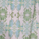 Luxury botanical fabric featuring layered wildflower patterns in sage green, soft blue, and natural tones for modern traditional and collected interiors.