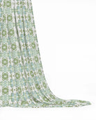 Luxury botanical fabric featuring layered wildflower patterns in sage green, soft blue, and natural tones for modern traditional and collected interiors.